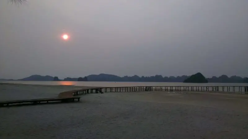 A long and windy wooden boardwalk at sunrise in Halong Bay