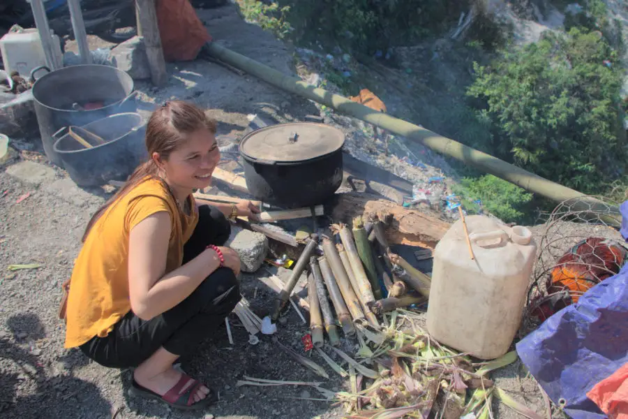 A Muong lady cooking on Thung Khe mountain pass where tourists stop to rest