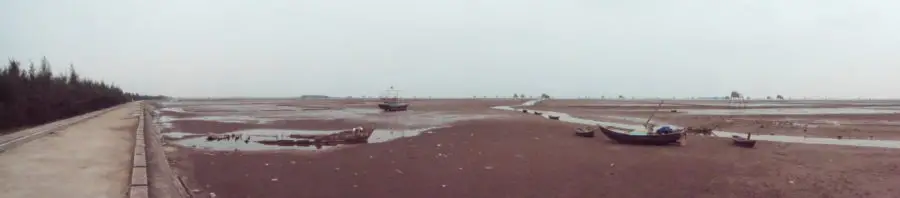 Boats on Dong Chau mud flats at low tide