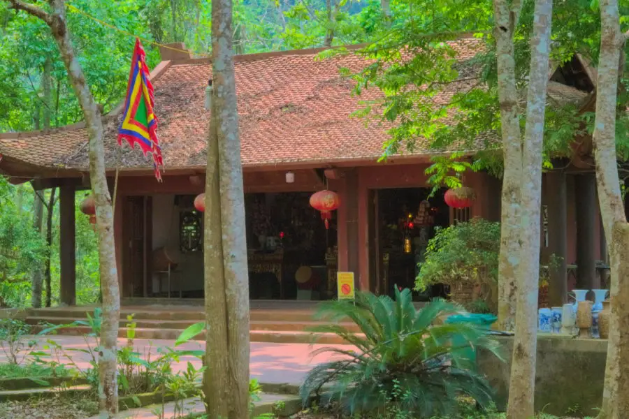 An old Vietnamese temple behind trees at Ba Be Lake