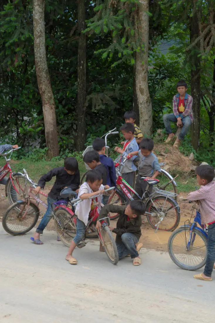 passing children with bicycles on a viet tracks motorbike tour