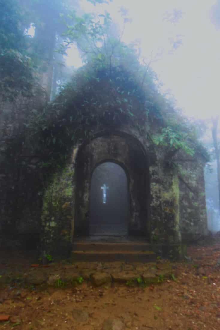 A crucifix shaped hole at the back of a church with light coming through