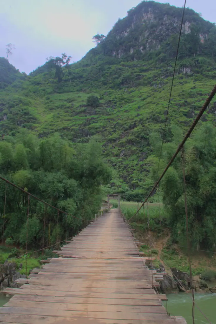Wood planked suspension brige over a river we cross on a ha giang motorbike tour