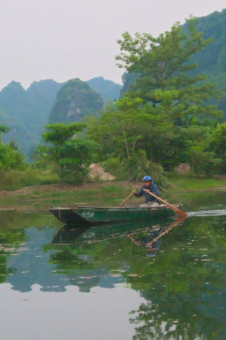 Vietnamese man rowing a boat in Ninh Binh