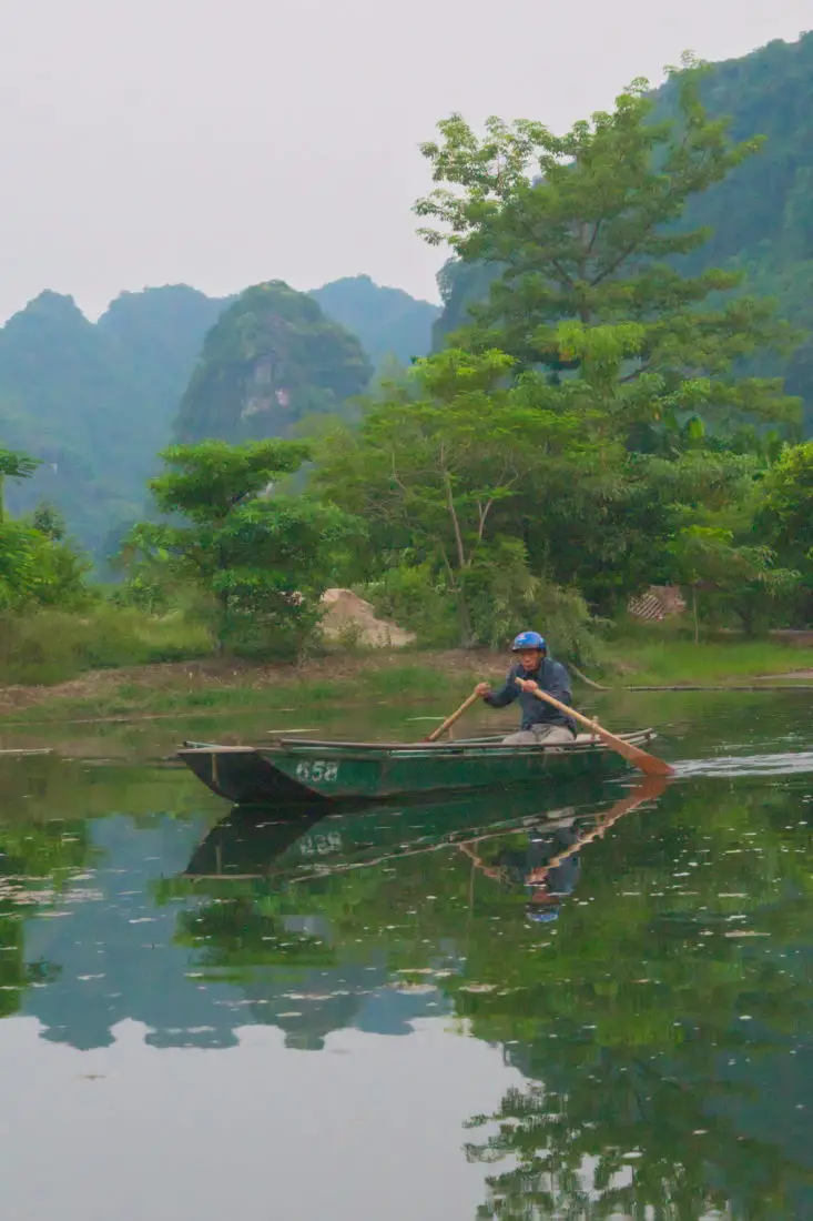 Vietnamese man rowing a boat in Ninh Binh