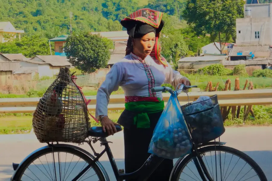 A minority lady selling food by bicycle in Son La, Vietnam during a motorbike journey