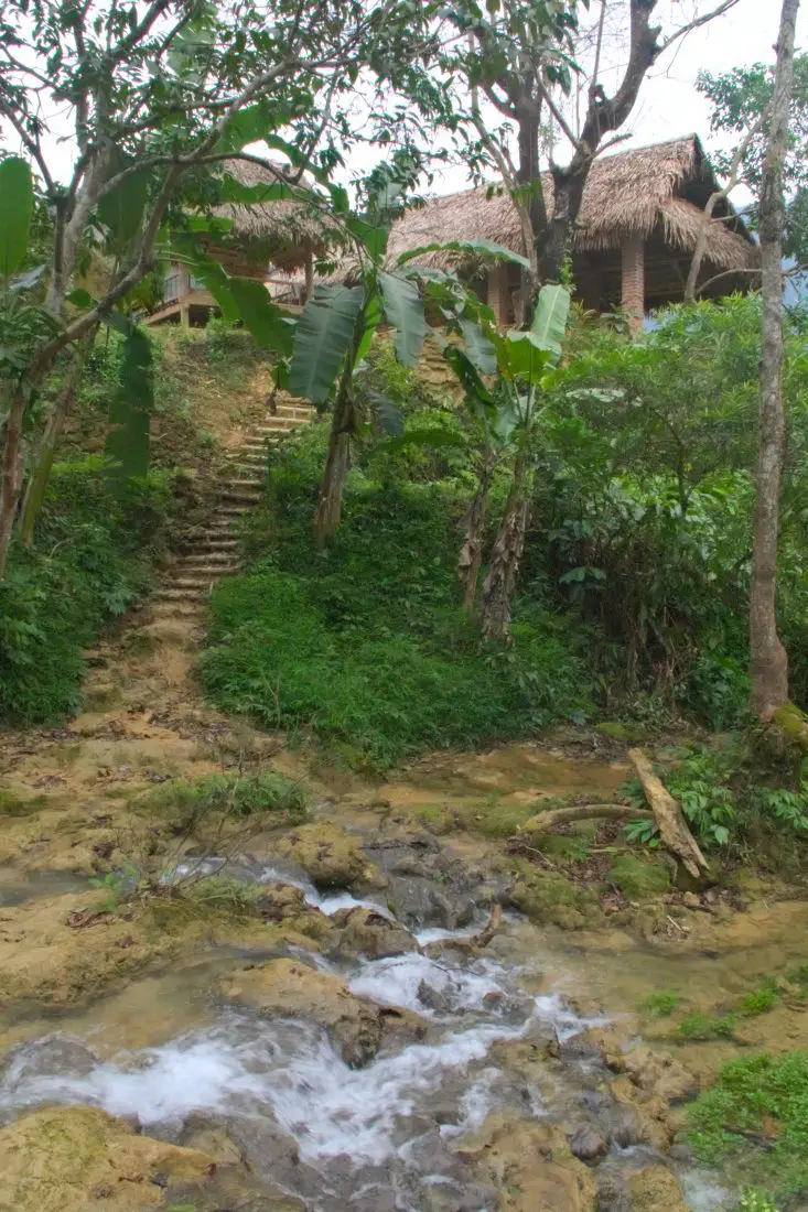 A wooden hut across a stream in the jungle of Vietnam