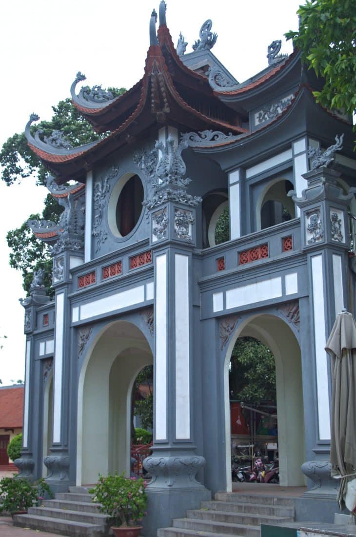 A gray gate entrance to a Vietnamese temple