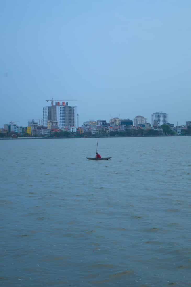 A man in a boat in West Lake, Hanoi, Vietnam