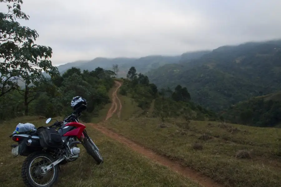 A red honda XR 150 next to a muddy trail