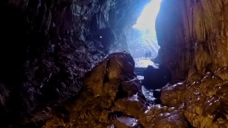 Inside a cave in Vietnam looking out past rock formations at Perfume Pagoda