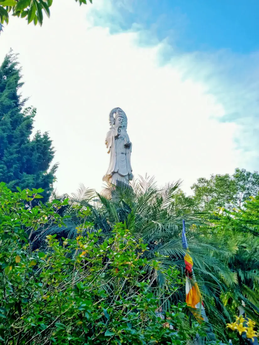 A buddhist statue at Chua Phat Quang in Hao Binh with the sun behind it