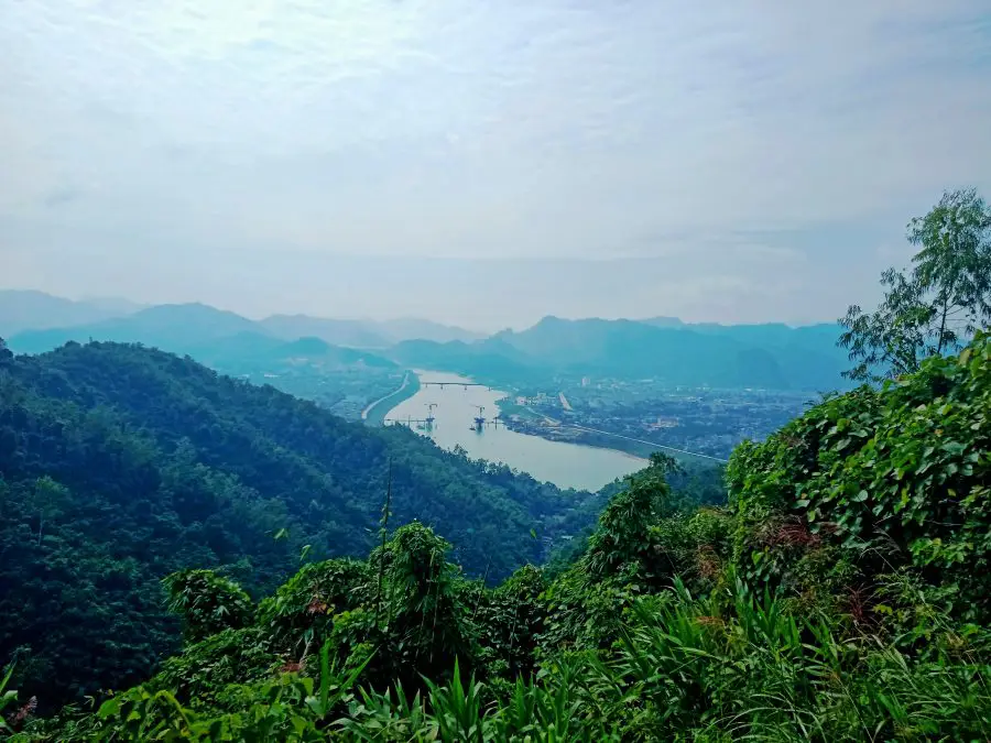 A view of a river in the distance surrounded by green mountains